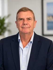 Professional head-and-shoulders portrait of the CGO Media founder Roger Wilkinson wearing a navy blazer and light blue shirt.